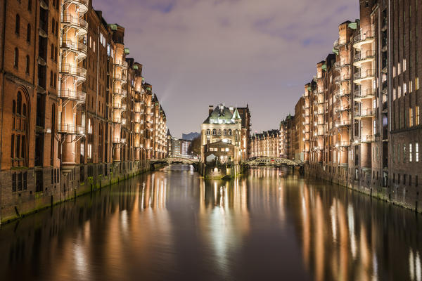 The water castle and buildings are reflected in the canal at dusk Poggenmühlenbrücke Altstadt Hamburg Germany Europe