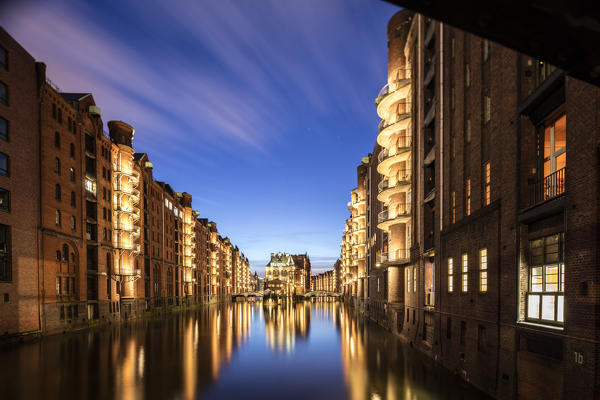 Blue dusk and lights are reflected in Poggenmühlenbrücke with water castle between bridges Altstadt Hamburg Germany Europe