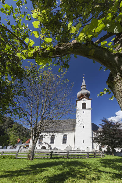 Typical church of alpine village surrounded by peaks and woods Garmisch Partenkirchen Oberbayern region Bavaria Germany Europe