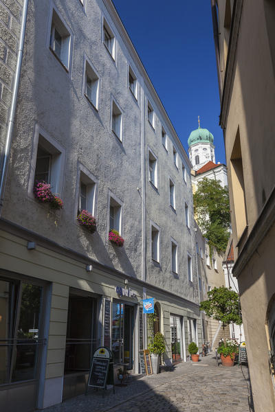 Typical alley of the old centre town with bell tower in the background framed by blue sky Passau Lower Bavaria Germany Europe