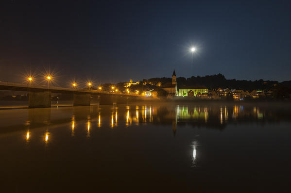 Night view of the old city with the bell tower and full moon reflected in the river Passau Lower Bavaria Germany Europe
