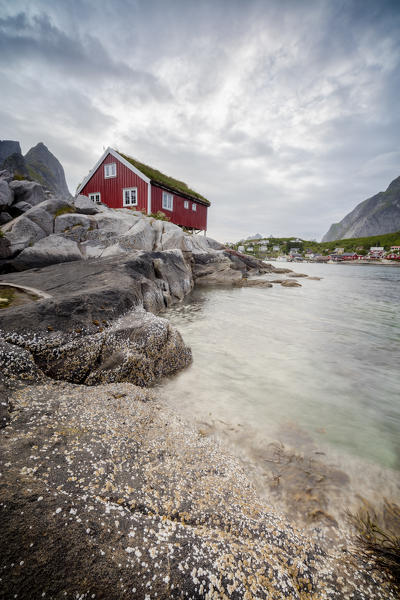 Clear water and rocky peaks frame the fishing village of Reine Nordland county Lofoten Islands Northern Norway Europe