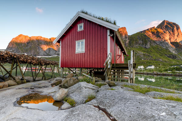 Typical house of fishermen called Rorbu lighted up by midnight sun Reine Nordland county Lofoten Islands Northern Norway Europe