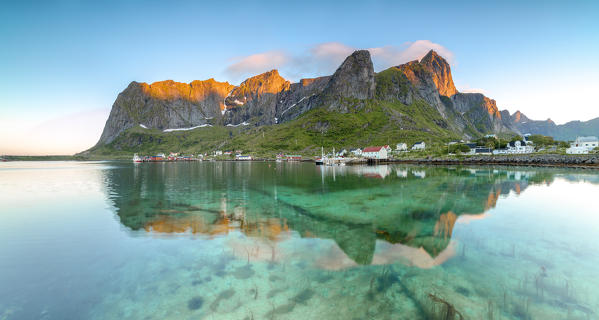 Panoramic of peaks reflected in clear water under the midnight sun Reine Nordland county Lofoten Islands Northern Norway Europe