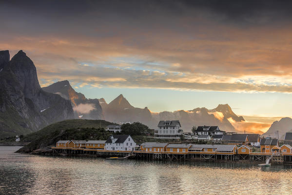 Sunset on the fishing village frames by rocky peaks and sea Sakrisoya Nordland county Lofoten Islands Northern Norway Europe
