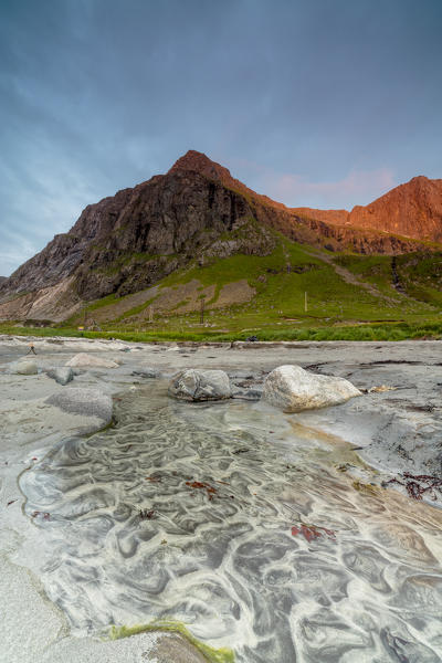 The midnight sun light up the rocky peaks and beach Skagsanden Ramberg Nordland county Lofoten Islands Northern Norway Europe