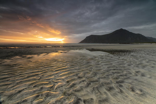 Midnight sun and clouds frame the sandy beach of Skagsanden Ramberg Nordland county Lofoten Islands Northern Norway Europe