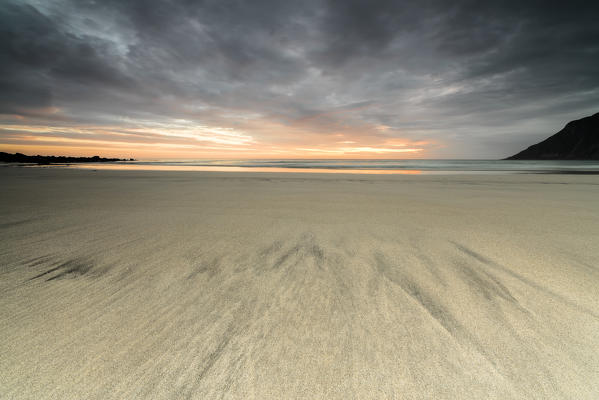 Midnight sun and clouds frame the sandy beach of Skagsanden Ramberg Nordland county Lofoten Islands Northern Norway Europe