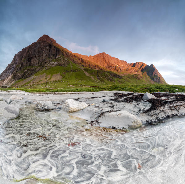 Panoramic of rocky peaks lighted up by midnight sun Skagsanden Ramberg Nordland county Lofoten Islands Northern Norway Europe