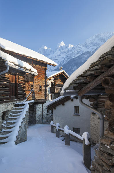 Snowy mountain huts framed by blue sky Soglio canton of Graubünden Maloja District Bregaglia Valley Engadine Switzerland Europe