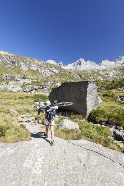 Cyclist with mountain bike ready for a ride Porcellizzo Valley Masino Valley Valtellina  Sondrio Province Lombardy Italy Europe