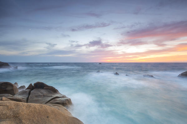 The fiery sky frames the waves crashing on rocks Capo Testa Santa Teresa di Gallura Province of Sassari Sardinia Italy Europe