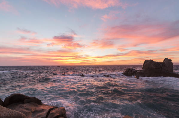 Pink sky at sunset on the waves crashing on cliffs Capo Testa Santa Teresa di Gallura Province of Sassari Sardinia Italy Europe