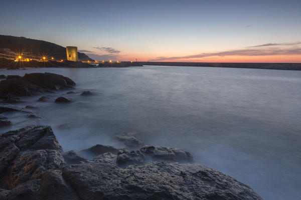 Dusk lights on medieval Tower of Frigiano framed by sea Castelsardo Gulf of Asinara Province of Sassari Sardinia Italy Europe