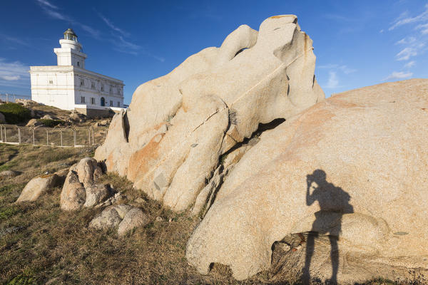 A silhouette is reflected on rocks next to lighthouse Capo Testa Santa Teresa di Gallura Sassari Province Sardinia Italy Europe