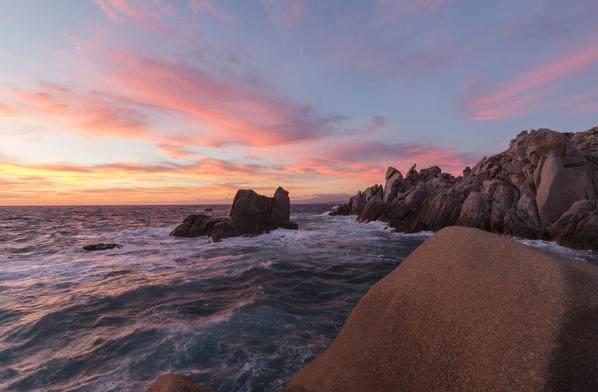 Pink sky at sunset on the waves crashing on cliffs Capo Testa Santa Teresa di Gallura Province of Sassari Sardinia Italy Europe