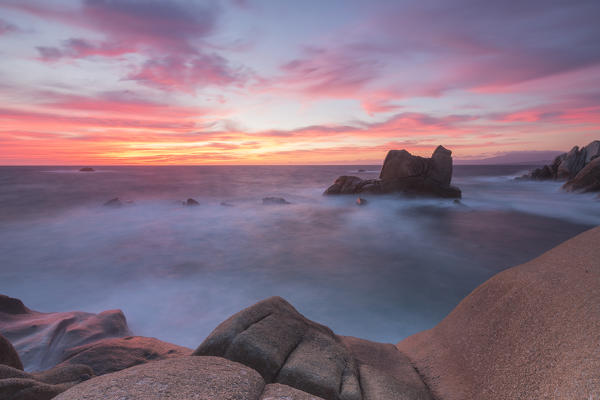 Pink sky at sunset on the waves crashing on cliffs Capo Testa Santa Teresa di Gallura Province of Sassari Sardinia Italy Europe
