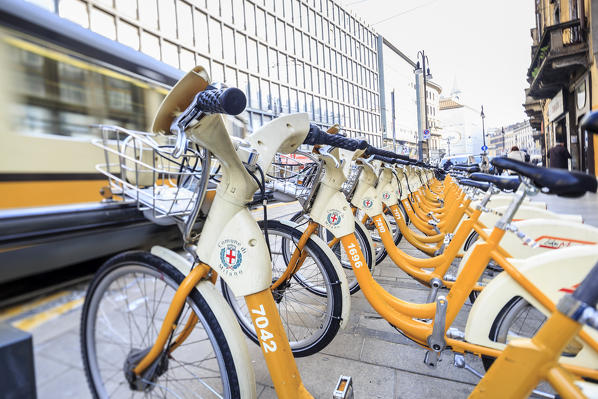 The deposit of city bikes sharing and the old yellow tram Milan Lombardy Italy Europe