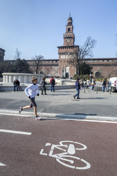 A runner on the cycle route beside the ancient Sforza Castle Milan Lombardy Italy Europe