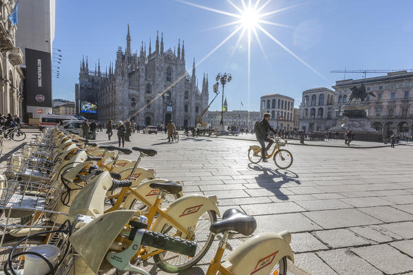 The yellow bicycles and cyclist in the main square of town facing the Duomo Milan Lombardy Italy Europe