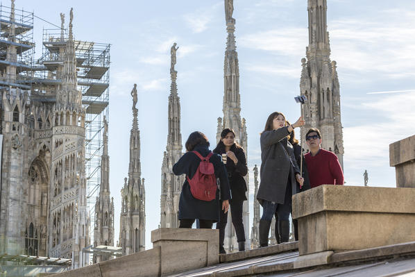Tourists among the white marble spiers on the top of the Duomo Milan Lombardy Italy Europe
