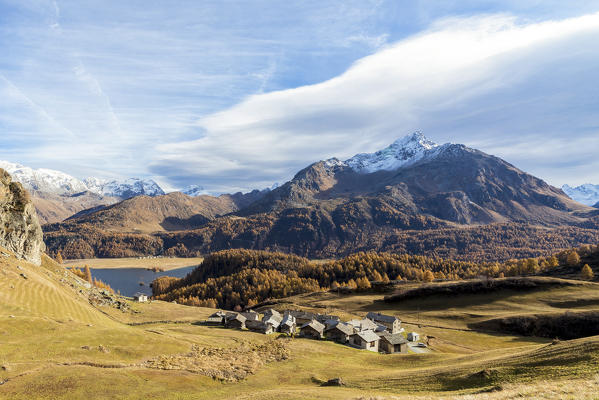 Huts and Lake Sils framed by the colorful woods in autumn Grevasalvas Upper Engadine Canton of Graubunden Switzerland Europe