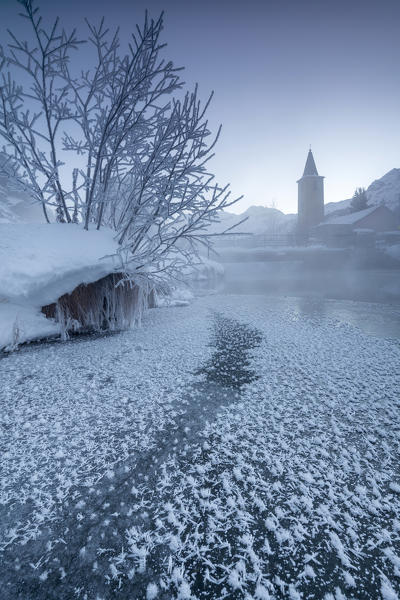The frozen river Inn framed by mist and snow at dawn Sils Canton of Graubunden Engadine Switzerland Europe