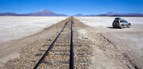 Tourists on a 4x4 crossing the long railway passing through the Salar de Uyuni in the South Lipez Bolivia South America