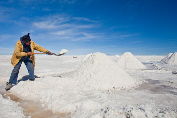 A salt worker in the Salar de Uyuni. As if the sun doesn't burn enough, the reflection off the salt is so intense the workers have to wear sunglasses and completely cover their bodies Bolivia South America