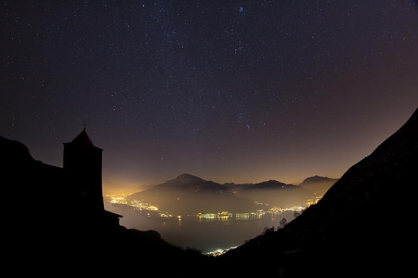 The bell tower of Saint Bernard Church in Musso in a starry night on the Lake Como Lombardy, Italy Europe