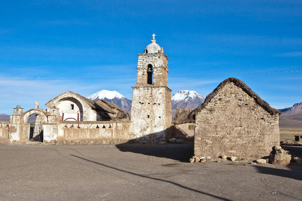 The church of Sajama and volcano Parinacota and Pomerape (Les Nevados de Payachatas). The Sajama Pueblo, in the Sajama National Parc, is the starting point of the climb of Nevado Sajama, the highest peak in Bolivia (6542m) - Bolivia, South America