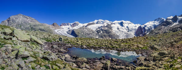 The peaks Palu and Belleviste in the Bernina group reflecting in a puddle in the Valley of Morteratsch in Engadine (Pontresina) . On the right you can see the Piz Bernina (4049 m) - Engadine, Switzerland Europe