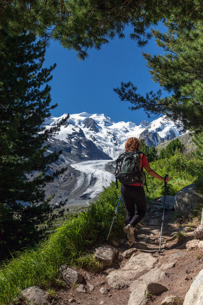 A hiker along one of the main trails in the Engadine Valley, where spectacular views over glaciers and snow-capped peaks abound, as in this case, with the view over the Bernina group. A delicious meal is a good reward at the Chamanna Boval hut - Engadine, Switzerland Europe