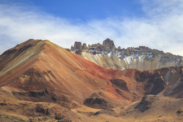 Climbing up Volcano Tunupa, the landscape takes on the rusty reds of the American West. A geological slideshow of dazzling shapes and colours awaits those who can reach its summit - Bolivia, South America