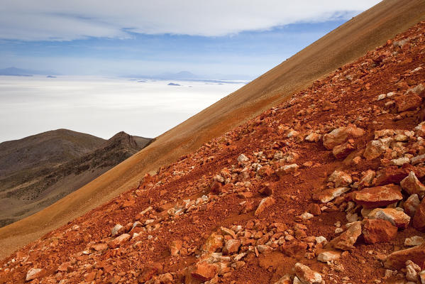 Climbing the highest peak of the salar de Uyuni, volcano Tunupa (Bolivia). The environment is unique and singular with the red rocks typical of volcanic areas and the view over the flat of the Salar de Uyuni. Here we are at 5000 meters, but there is still a lot to the top. South America