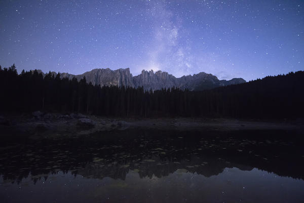 Stars on the peaks of Latemar mountain range reflected in Lake Carezza Ega Valley Province of Bolzano South Tyrol Italy Europe