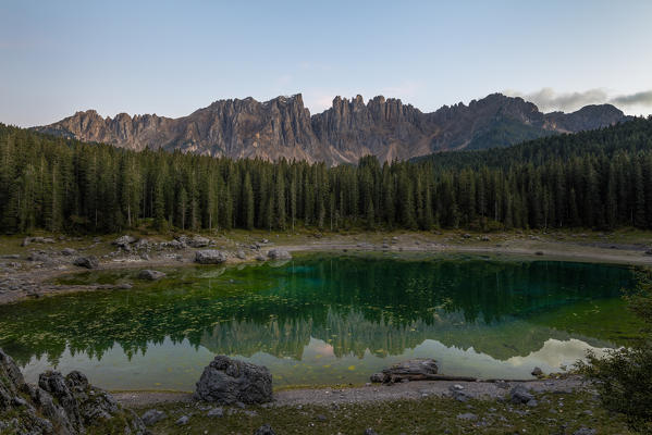 Latemar mountain range and woods are reflected in Lake Carezza at dusk Ega Valley Province of Bolzano South Tyrol Italy Europe