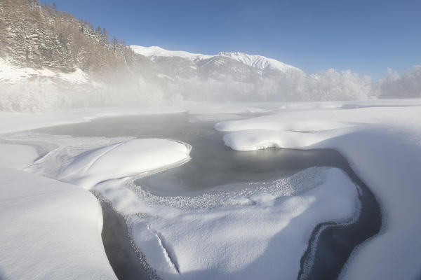 Mist on the snowy landscape and frozen river Inn Celerina Maloja Canton of Graubunden Engadine Switzerland Europe
