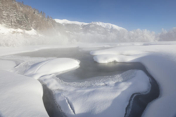 Mist on the snowy landscape and frozen river Inn Celerina Maloja Canton of Graubunden Engadine Switzerland Europe