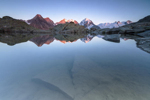 Snowy peaks reflected in the alpine lake at sunset Fuorcla Surlej St. Moritz Canton of Graubünden Engadine Switzerland Europe