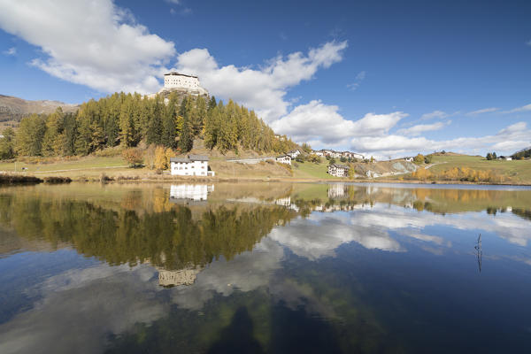 The ancient castle and colorful trees are reflected in Lake Tarasp Inn district Canton of Graubünden Engadine Switzerland Europe