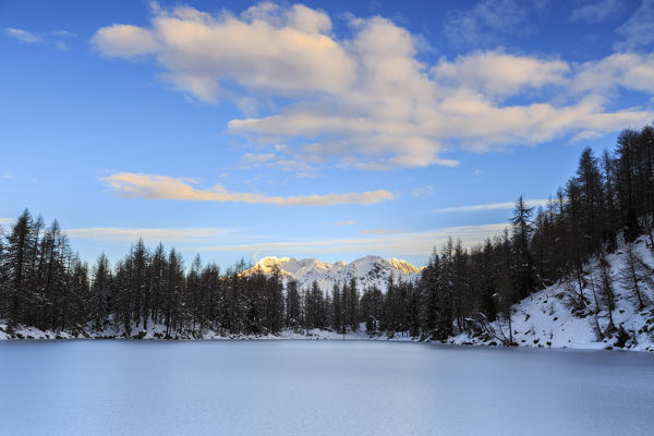The pink clouds frame the frozen Lago Azzurro at dawn Spluga Valley Province of Sondrio Valtellina Lombardy Italy Europe