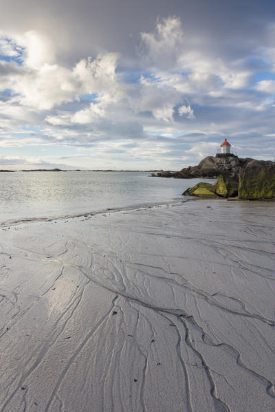 Midnight sun lights up cliffs and sandy beach surrounded by turquoise sea  Eggum Unstad Vestvagøy Lofoten Islands Norway Europe