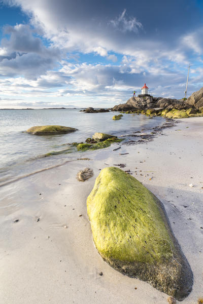 Midnight sun lights up cliffs and sandy beach surrounded by turquoise sea  Eggum Unstad Vestvagøy Lofoten Islands Norway Europe