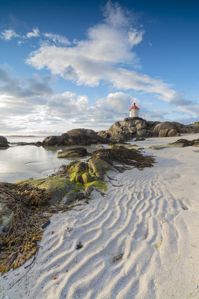 Midnight sun lights up lighthouse on cliffs surrounded by sea and sand Eggum Unstad Vestvagøy Lofoten Islands Norway Europe