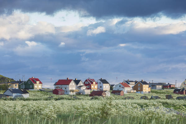 Clouds and midnight sun frames the typical houses of the fishing village Eggum Unstad Vestvagøy Lofoten Islands Norway Europe