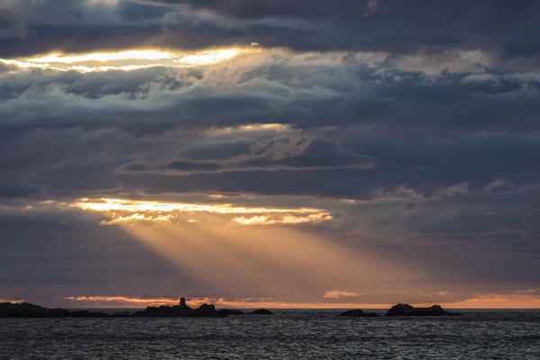 Rays of the midnight sun light up the lighthouse overlooking the sea Eggum Vestvagøy Lofoten Islands Norway Europe