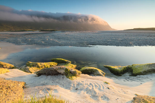 The midnight sun is reflected in the cold sea at summer Fredvang Moskenesøya Nordland county Lofoten Islands Norway Europe