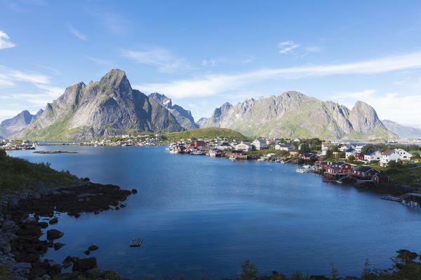 The blue sea frames the fishing village and the rocky peaks at dusk Reine Moskenes Lofoten Islands Norway Europe