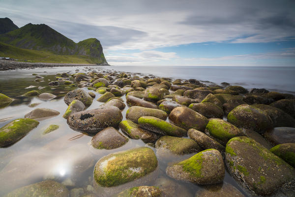 Rocks on the beach frame the calm clear sea Unstad Vestvagøy Lofoten Islands Norway Europe